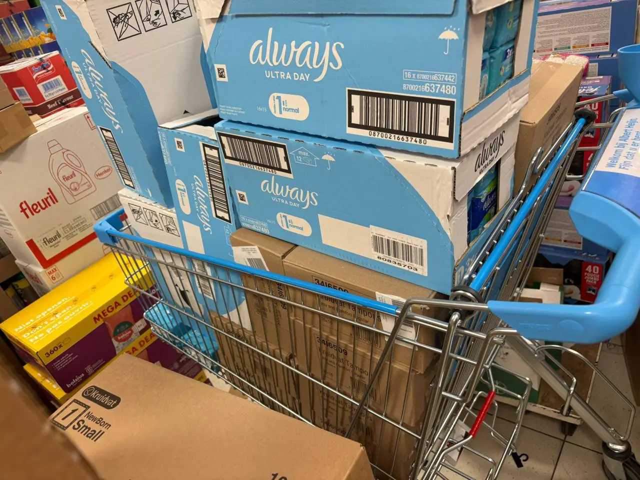Een winkelwagen vol dozen tampons en maandverband, ingekocht voor de menstruatieproducten-actie van de JAR.