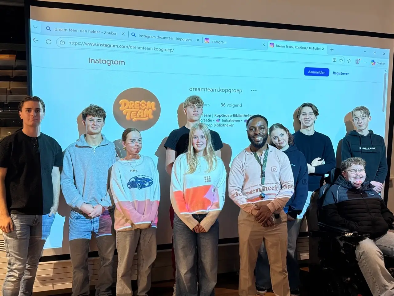 Leden van de JAR samen met Christian Nana van het Dream Team, voor een scherm met de Instagrampagina van het Dream Team.